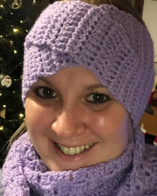 Alice smiling, wearing a lilac crochet headband and matching cowl
