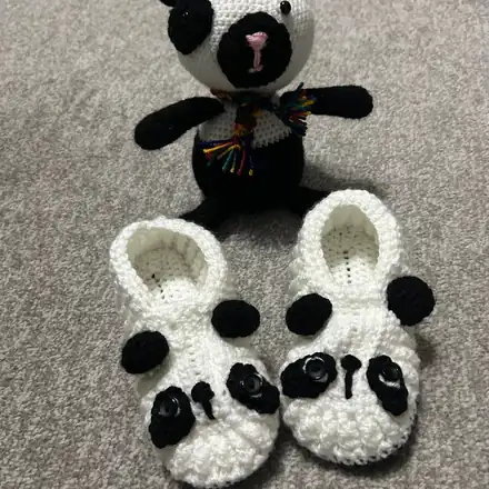 Panda baby slippers next to a little crochet panda